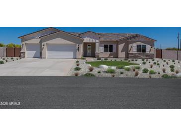 Charming single-story home boasting a well-maintained front yard with stone landscaping and a three-car garage at 10829 W Woodruff Rd, Casa Grande, AZ 85194