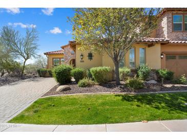Charming home featuring a well-manicured lawn and a beautiful tree in the front yard at 12047 W Red Hawk Dr, Peoria, AZ 85383