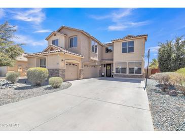 Spacious two-story home with desert landscaping, three-car garage and basketball hoop on the driveway at 1391 E Angie St, Casa Grande, AZ 85122