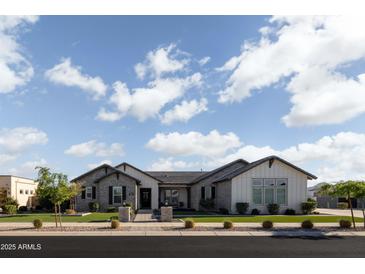 Charming single-story home with a brick facade, manicured lawn, and a welcoming entrance at 19901 E Country Meadows Dr, Queen Creek, AZ 85142