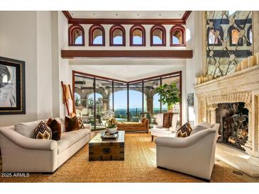 Bright living room with high ceilings, fireplace, large picture window, and sophisticated decor at 26796 N 98Th Way, Scottsdale, AZ 85262