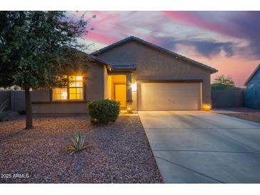 Charming single-story home featuring a two-car garage and low-maintenance desert landscaping at dusk at 30370 N Opal Dr, San Tan Valley, AZ 85143