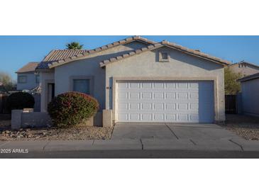 Charming single-story home features a two-car garage, desert landscaping, and a neutral color palette at 6538 W Elwood St, Phoenix, AZ 85043