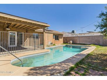 Backyard pool featuring cool blue water, a lounging area, and a covered patio area at 2049 W Joan De Arc Ave, Phoenix, AZ 85029