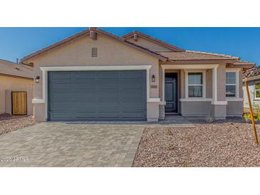Charming home showcasing a spacious gray garage door and desert landscaping at 25314 N 133Rd Ave, Peoria, AZ 85383