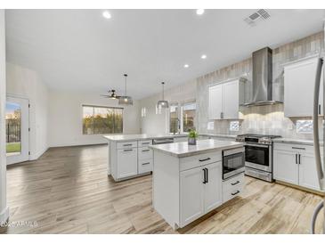 Open kitchen with white cabinets, stainless appliances, and expansive island for food prep and entertaining at 32806 N 55Th Pl, Cave Creek, AZ 85331