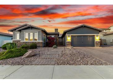 Charming single-Gathering home with a two-car garage, desert landscaping and a brick walkway leading to the front door at 3522 E Penedes Dr, Gilbert, AZ 85298