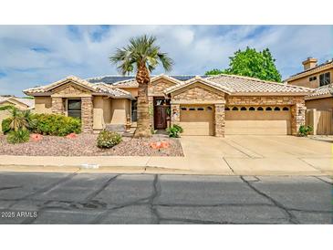 Charming single-story home with stone accents, desert landscaping, and a well-manicured front yard at 6158 W Donald Dr, Glendale, AZ 85310