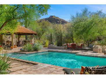 Stunning pool area with a mountain view, covered patio, lounge chairs, and desert landscaping at 6301 N Camelback Manor Dr, Paradise Valley, AZ 85253