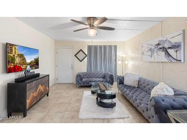 Cozy living room with stylish sofas, modern decor, and a ceiling fan for comfortable living at 7110 E Continental Dr # 1044, Scottsdale, AZ 85257