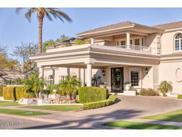 Stately home featuring manicured landscaping, a circular drive, and an impressive covered entryway at 7630 E Vaquero Dr, Scottsdale, AZ 85258