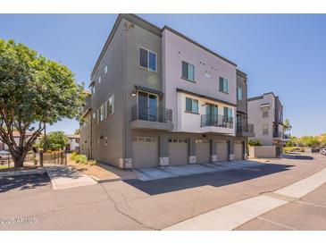 Modern townhome featuring a private balcony, gray paint scheme, and individual garages at 300 N Gila Springs Blvd # 144, Chandler, AZ 85226