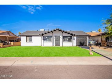 Charming single-story home featuring a well-manicured lawn and a classic design at 5948 W Holly St, Phoenix, AZ 85035