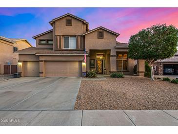 Inviting two-story home with a three car garage and desert landscaping at 6971 W El Cortez Pl, Peoria, AZ 85383