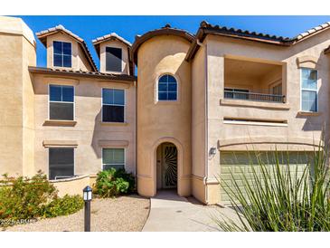 Charming three-story home with a private balcony, two-car garage, and landscaped front yard with stone pathway at 14575 W Mountain View Blvd # 621, Surprise, AZ 85374