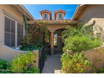 Charming front entrance with lush landscaping, tiled roof, and beautiful blooming vines at 18575 E Pine Barrens Ave, Queen Creek, AZ 85142
