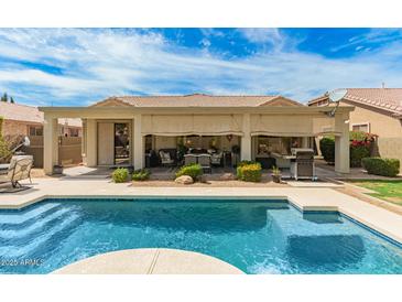 Stunning backyard features a sparkling pool, covered patio, and lush landscaping at 3871 S Marion Way, Chandler, AZ 85286