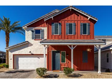 Charming two-story home features a red exterior with blue shutters and a well-manicured front yard at 399 N 157Th Ln, Goodyear, AZ 85338