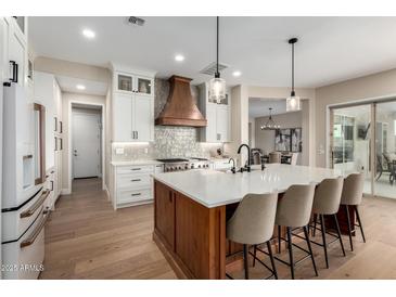 Bright kitchen showcasing a large island with seating, wood accents and modern appliances at 6209 E Bramble Berry Ln, Cave Creek, AZ 85331