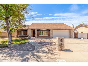 Charming single-story home with a well-manicured front yard and inviting curb appeal under a blue sky at 6608 S Willow Dr, Tempe, AZ 85283