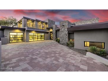 Modern home featuring stone accents, a glass garage door, and a spacious driveway at 9127 N Fireridge Trl, Fountain Hills, AZ 85268