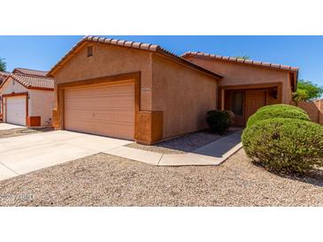 Charming single-story home with a two-car garage, desert landscaping, and a cozy front entrance at 1384 E Press Rd, San Tan Valley, AZ 85140