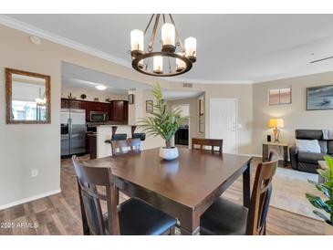 Inviting dining area featuring a chandelier and wood table, set in a neutral color palette at 20801 N 90Th Pl # 242, Scottsdale, AZ 85255
