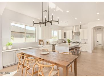 Bright, spacious kitchen with stainless appliances, central island, and adjacent dining area at 19162 E Mockingbird Dr, Queen Creek, AZ 85142