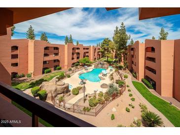 Exterior shot from above of the community pool with buildings, rocks, plants, and trees surrounding it at 4303 E Cactus Rd # 407, Phoenix, AZ 85032