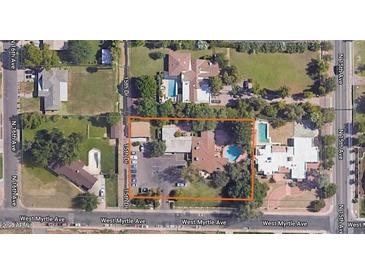 Expansive aerial view showcasing a charming neighborhood with mature trees and a sparkling blue pool on a sunny day at 1522 W Myrtle Ave, Phoenix, AZ 85021
