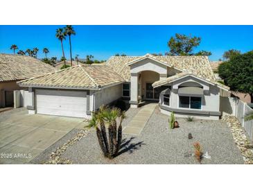 Charming single-story home featuring desert landscaping, a two-car garage, and a welcoming front entryway at 17514 N Rainbow Cir, Surprise, AZ 85374