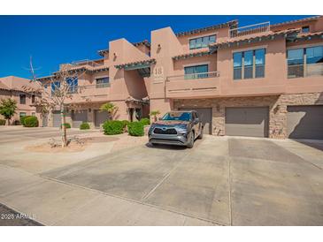 Condominium exterior showcasing well-maintained grounds, garage parking, and attractive architecture at 20660 N 40Th St # 1112, Phoenix, AZ 85050