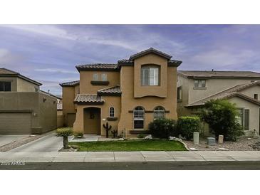 Stunning two-story stucco home with a tile roof, arched windows, and a well-manicured lawn at 2673 E Remington Pl, Chandler, AZ 85286