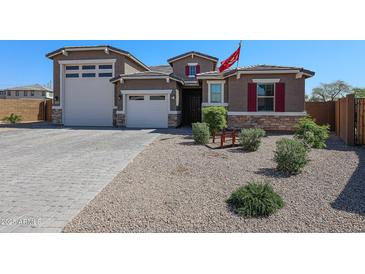 Charming home exterior with a well-manicured front yard and a three car garage at 3907 S 75Th Dr, Phoenix, AZ 85043