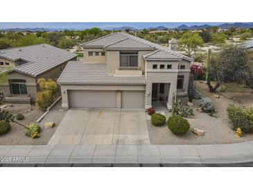 Beautiful desert-landscaped home boasts a three-car garage and a tile roof at 4864 E Eden Dr, Cave Creek, AZ 85331