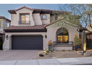 Elegant two-story home boasts desert landscaping, a dark garage door and a beautiful clay tile roof at 9858 E South Bend Dr, Scottsdale, AZ 85255