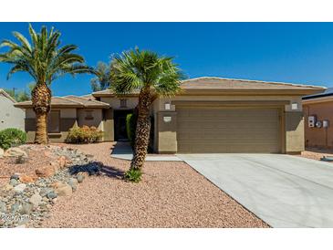 Charming home featuring desert landscaping, a two-car garage, and beautiful palm trees at 15136 W Cactus Ridge Way, Surprise, AZ 85374