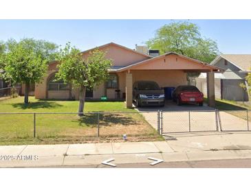 Charming single-story home featuring a covered carport and a well-maintained fenced yard at 2513 E Randall Dr, Tempe, AZ 85288