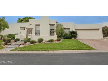 Stylish stucco home featuring neat landscaping, trimmed lawn, and brick-paved driveway leading to a two-car garage at 6278 N 31St Way, Phoenix, AZ 85016