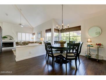 This dining room features hardwood floors, a chandelier, and large windows with natural light at 10015 E Mountain View Rd # 2012, Scottsdale, AZ 85258
