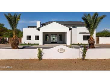 Stunning white home boasts modern design, desert landscaping, and a welcoming entryway with a tile roof at 10620 N 84Th St, Scottsdale, AZ 85260