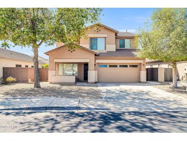 Inviting two-story home with a well-manicured front yard and attached two car garage at 14521 W Gelding Dr, Surprise, AZ 85379