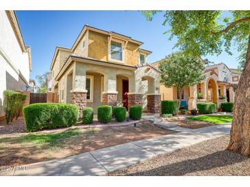 Charming two-story home with stucco siding, stone accents, well-manicured landscaping, and covered front porch at 4252 E Vest Ave, Gilbert, AZ 85295