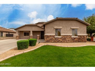 Charming single-story home showcasing appealing stone accents, manicured lawn and desert landscaping at 4255 S Marisol Ln, Gilbert, AZ 85297