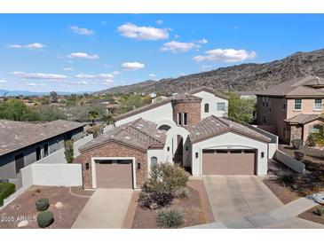 Aerial view of a stunning home with a three-car garage, desert landscaping, and a mountain backdrop at 8817 S 18Th Way, Phoenix, AZ 85042
