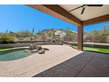 Relaxing backyard featuring a pool, putting green, desert landscaping, and mountain views at 11451 E Christmas Cholla Dr, Scottsdale, AZ 85255