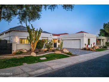 Charming single-story home with desert landscaping, paved driveway and attached garage at 11977 N 81St St, Scottsdale, AZ 85260