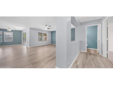 Bright living room features vinyl flooring, large windows for natural light, and ceiling fan for comfort at 15825 W Acapulco Ln, Surprise, AZ 85379