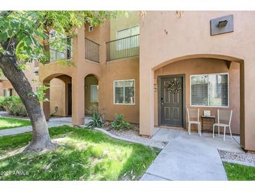Charming condo entrance with wreath-adorned door, quaint seating area, and desert-friendly landscaping at 1718 W Colter St # 184, Phoenix, AZ 85015