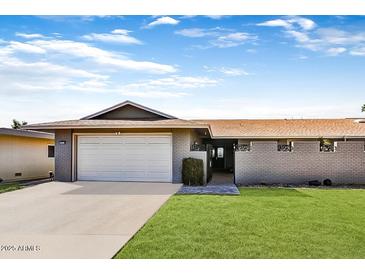 Charming single-story home with a well-maintained lawn, attached garage, and inviting walkway at 18410 N 104Th Ave, Sun City, AZ 85373